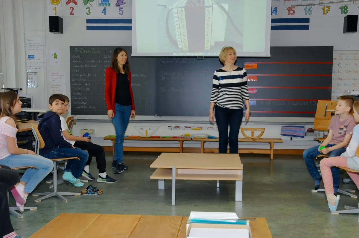 Man sieht Schulkinder ihr Schulprojekt vorstellen.
